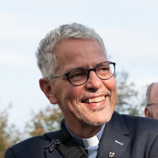 Pater Norbert Thuex lächelt - dahiter weitere Pater