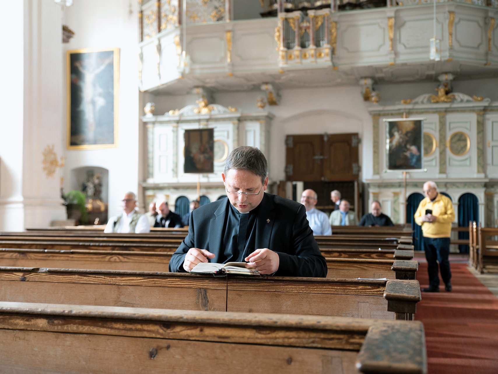 Pater beim Gebet in der Kirchenbank