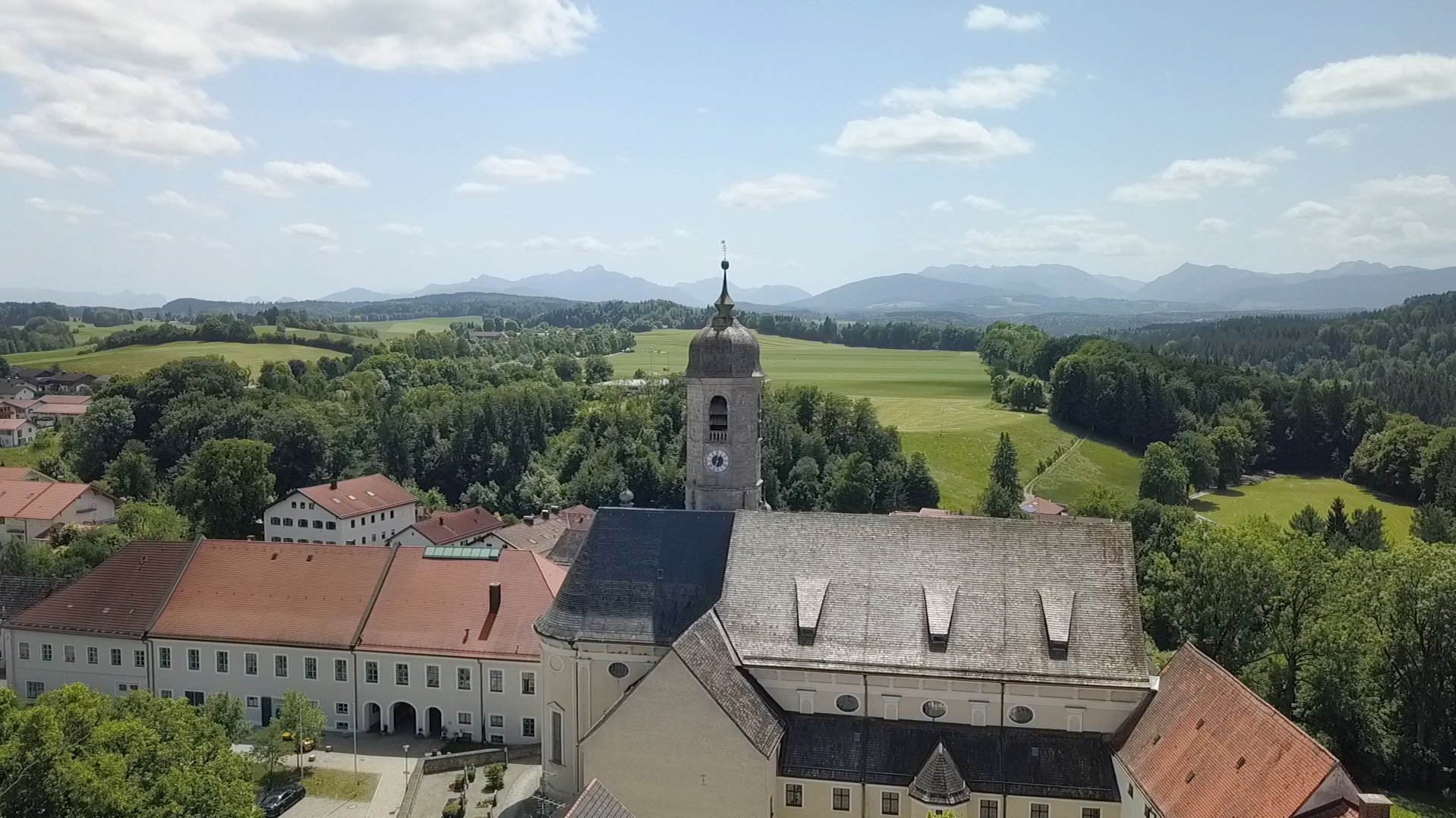 Kirchturm mit Alpen im Hintergrund